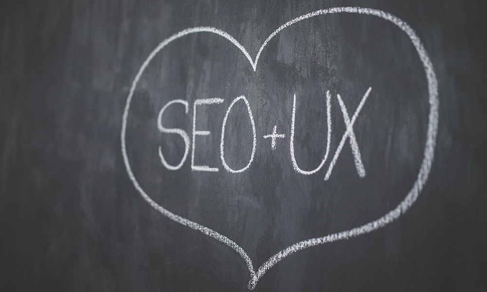 A chalkboard with "SEO + UX" written inside a heart, symbolizing the close relationship between Search Engine Optimization and User Experience.